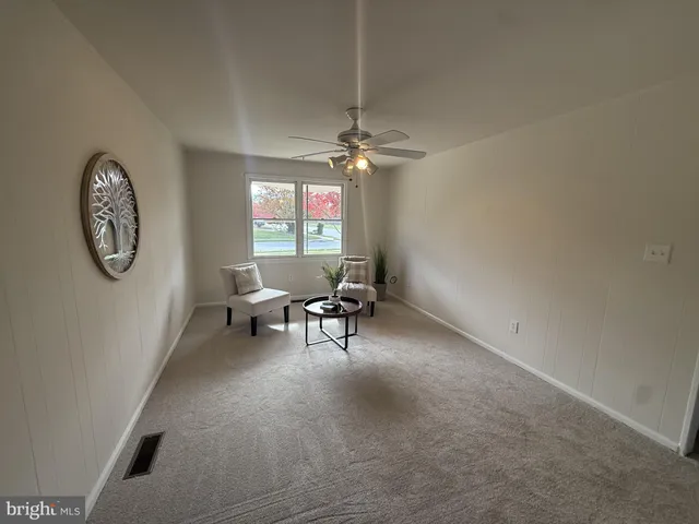 a living room with furniture a chandelier and a window