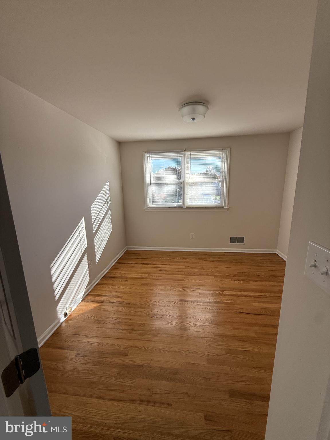 513 Pershing Road Hockessin, DE 19707 - Photo 14 of 17 a view of an empty room with wooden floor and a window