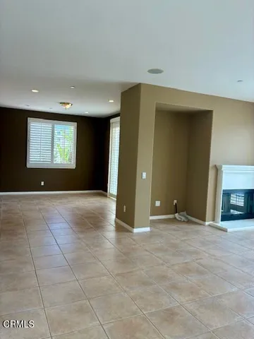a view of an empty room with window and fireplace