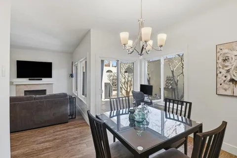 a view of a dining room with furniture a chandelier and wooden floor