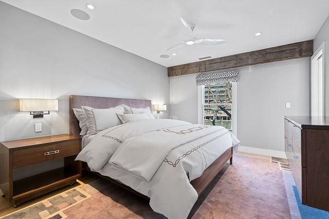 a bedroom with a bed and a lamp on dresser