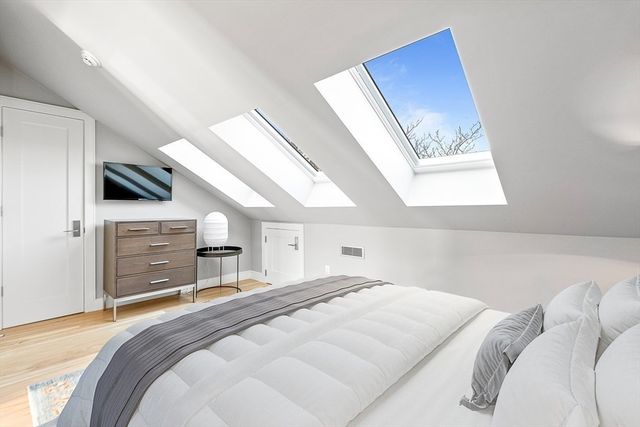 a bedroom with a bed a dresser and a large mirror