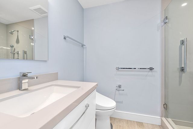 a bathroom with a sink a toilet and shower