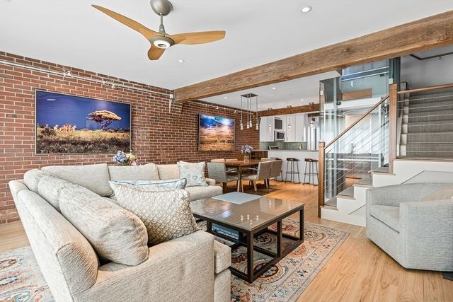a living room with furniture a rug and a ceiling fan