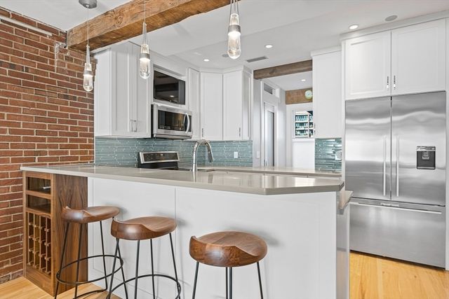 a kitchen with stainless steel appliances granite countertop a stove a sink and a refrigerator