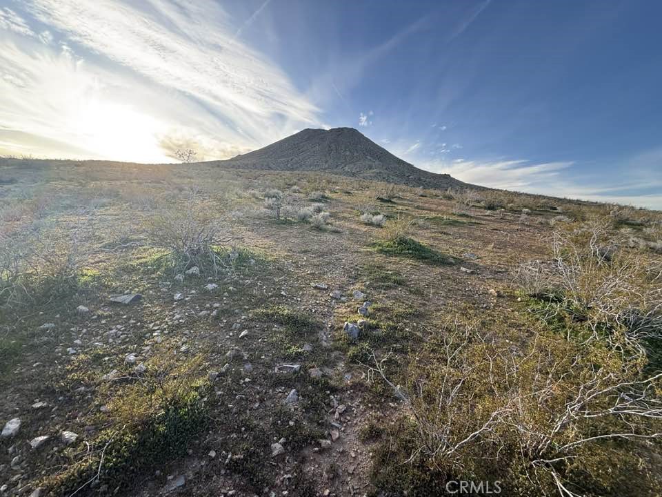 a view of mountain with sunset in background