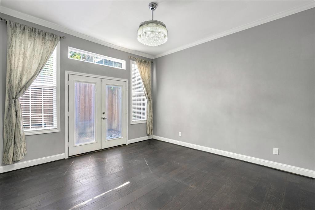 4511 Gilbert Avenue, Unit 108 Dallas, TX 75219 - Photo 11 of 25 an empty room with wooden floor door and windows