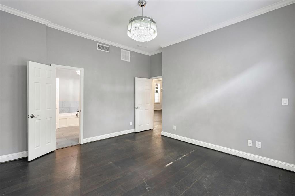 4511 Gilbert Avenue, Unit 108 Dallas, TX 75219 - Photo 12 of 25 an empty room with wooden floor and windows