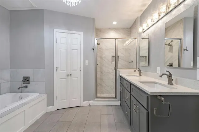 a bathroom with a double vanity sink a mirror and a bathtub