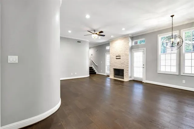 an empty room with windows and fireplace