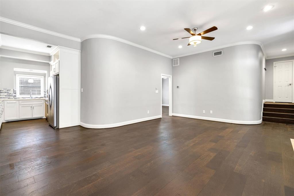 4511 Gilbert Avenue, Unit 108 Dallas, TX 75219 - Photo 7 of 25 a view of an empty room with a window and wooden floor
