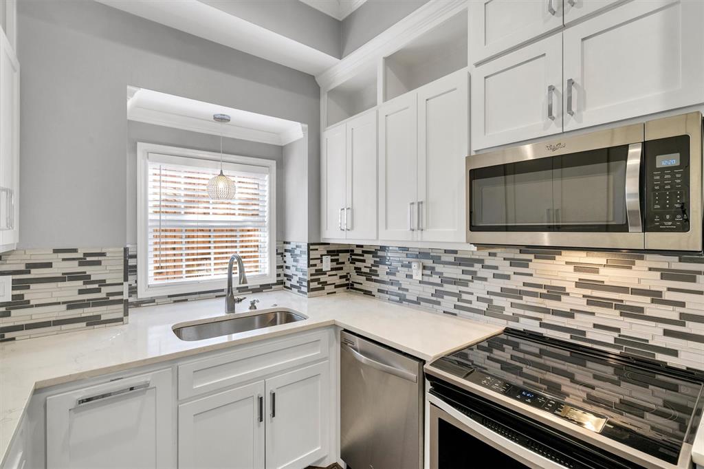 4511 Gilbert Avenue, Unit 108 Dallas, TX 75219 - Photo 9 of 25 a kitchen with stainless steel appliances a sink stove and microwave