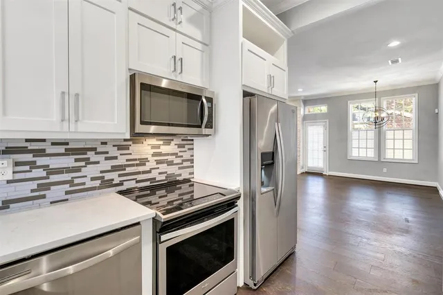 a kitchen with stainless steel appliances a stove microwave and refrigerator