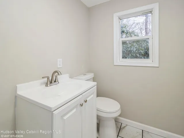 a bathroom with a sink a toilet and a window