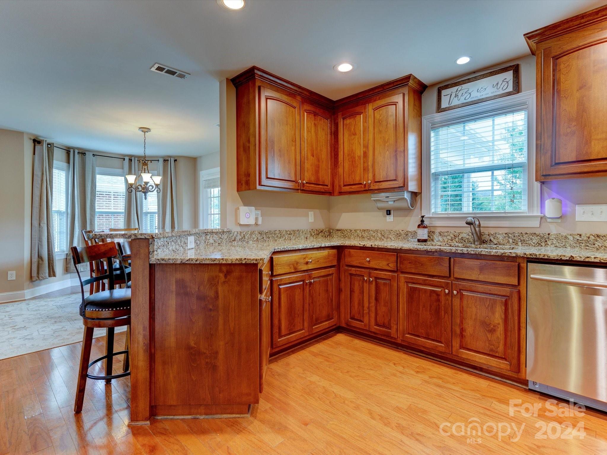 4403 Zee Court Monroe, NC 28110 - Photo 10 of 35 a kitchen with stainless steel appliances granite countertop wooden cabinets a sink and dishwasher with wooden floor