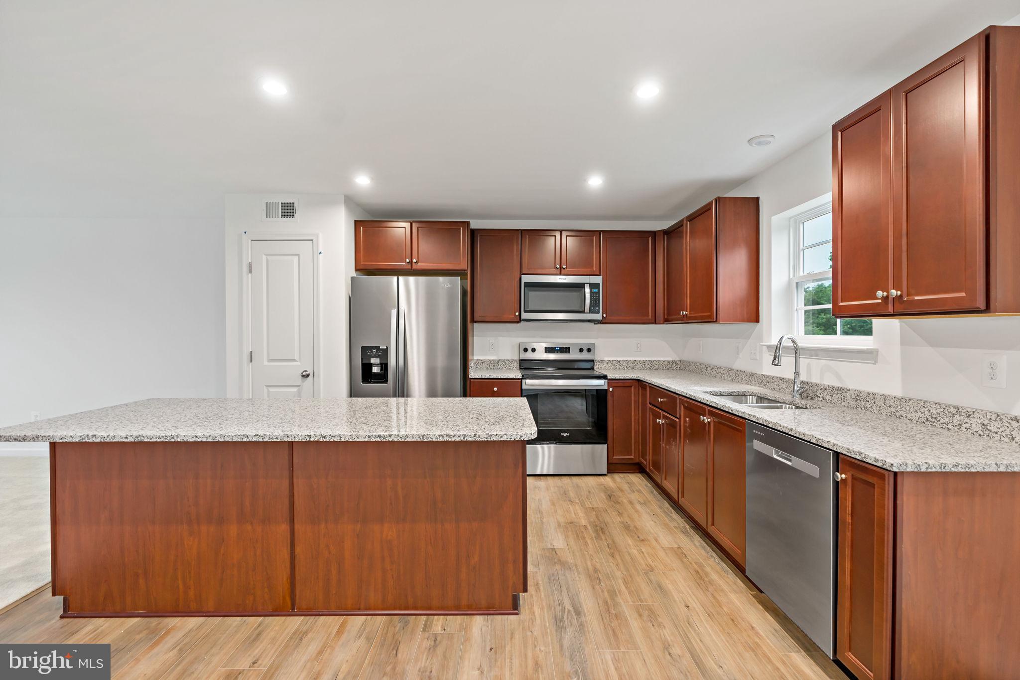 171 Grayling Road Inwood, WV 25428 - Photo 5 of 39 a large kitchen with stainless steel appliances granite countertop a stove a sink dishwasher a refrigerator and a oven with wooden floor