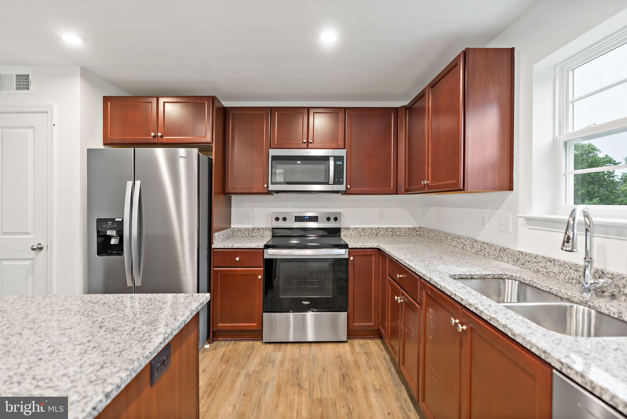 171 Grayling Road Inwood, WV 25428 - Photo 6 of 39 a kitchen with granite countertop wooden cabinets a sink and stainless steel appliances