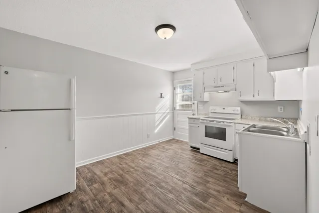 a kitchen with white cabinets and white appliances