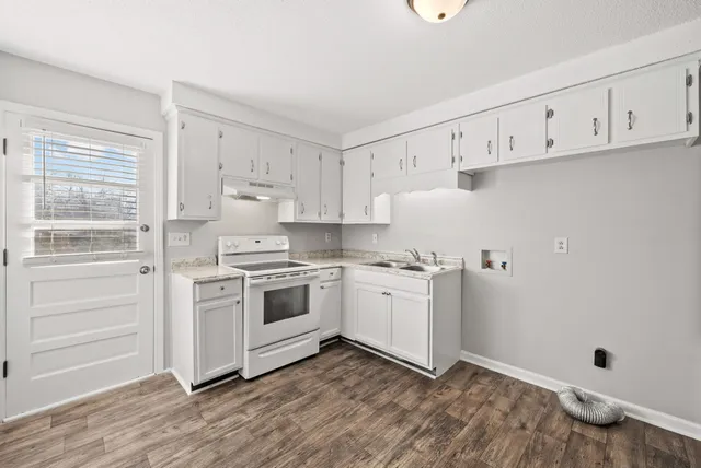 a kitchen with granite countertop white cabinets and white appliances