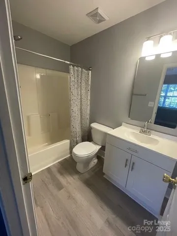 a bathroom with a toilet a sink a mirror and a shower