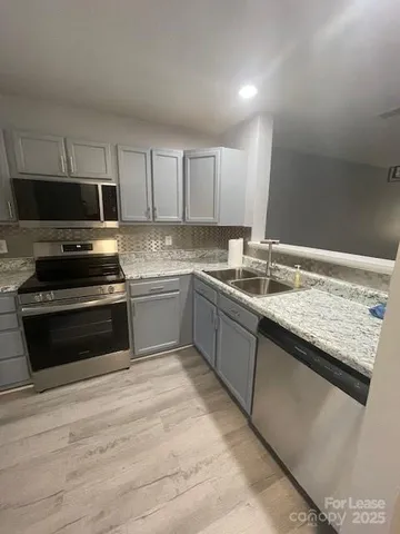 a kitchen with granite countertop a sink and steel appliances