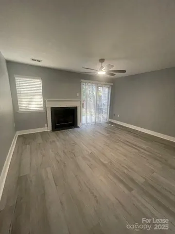 an empty room with windows and fireplace