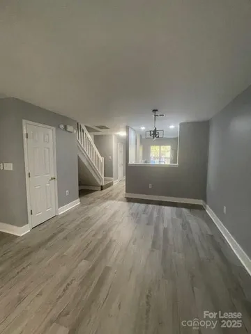 an empty room with wooden floor and window