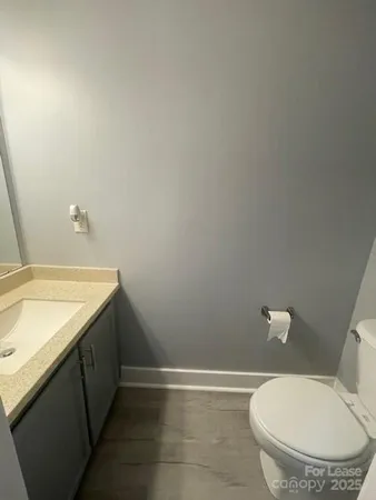 a bathroom with a granite countertop sink and a toilet