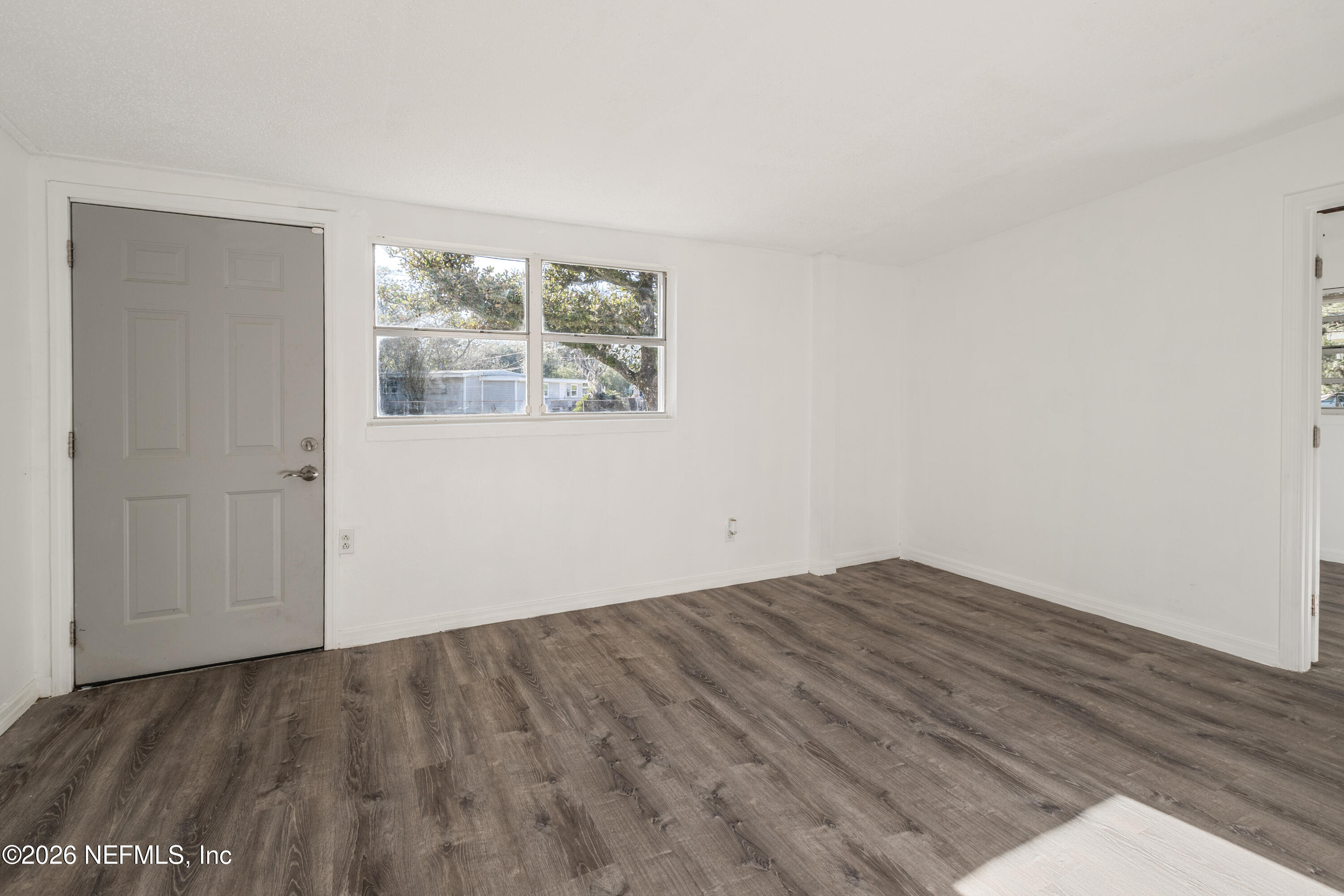 1841 Griflet Road Jacksonville, FL 32211 - Photo 12 of 23 an empty room with wooden floor and windows