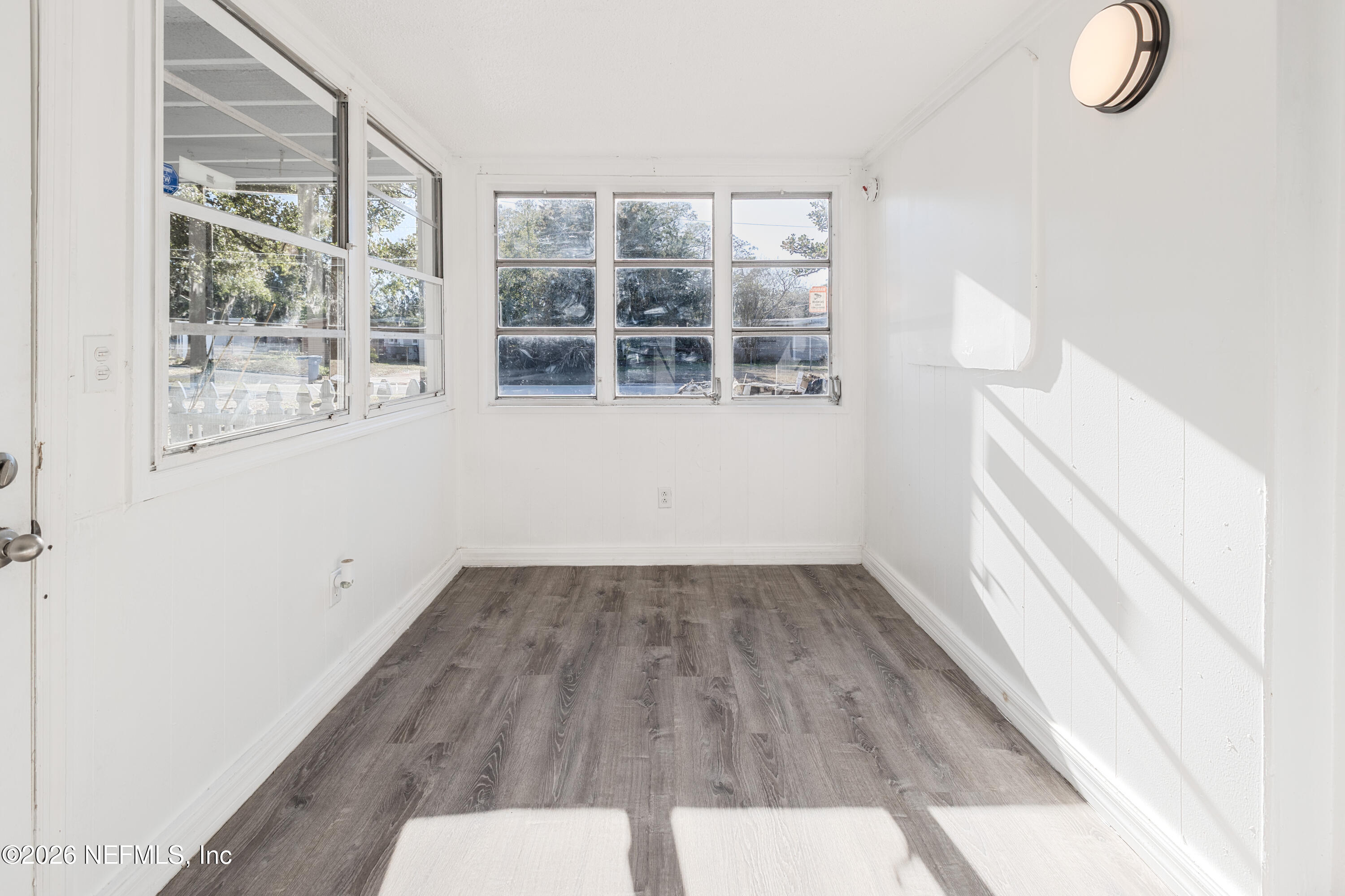 1841 Griflet Road Jacksonville, FL 32211 - Photo 9 of 23 an empty room with wooden floor and windows