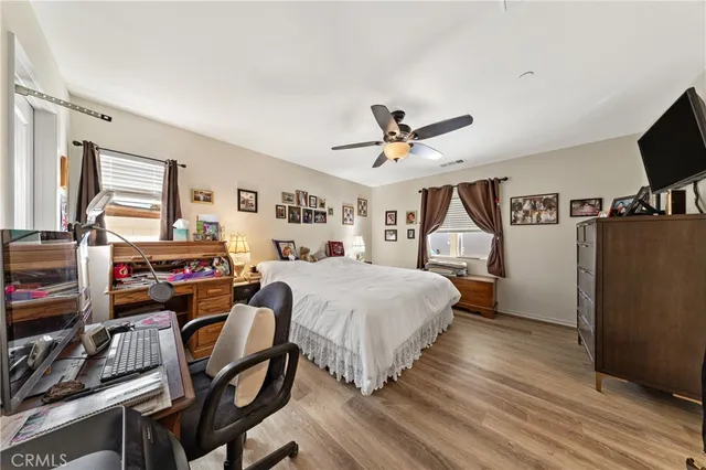 a spacious bedroom with a bed and a flat screen tv