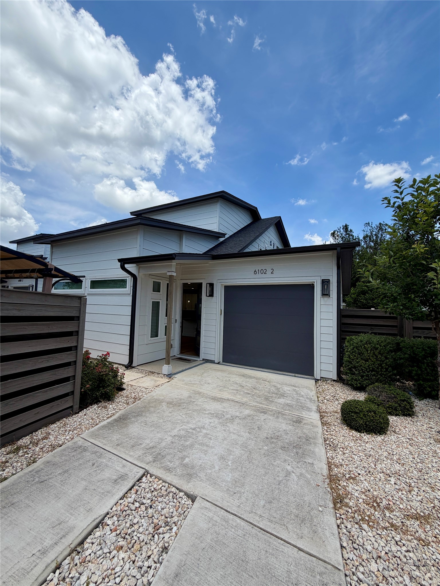 6102 Ponca Street, Unit 2 Austin, TX 78741 - Photo 1 of 24 A modern facade with a dark garage door and light siding welcomes you home.
