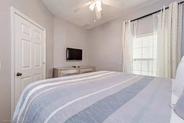 a bedroom with a bed tv and a window