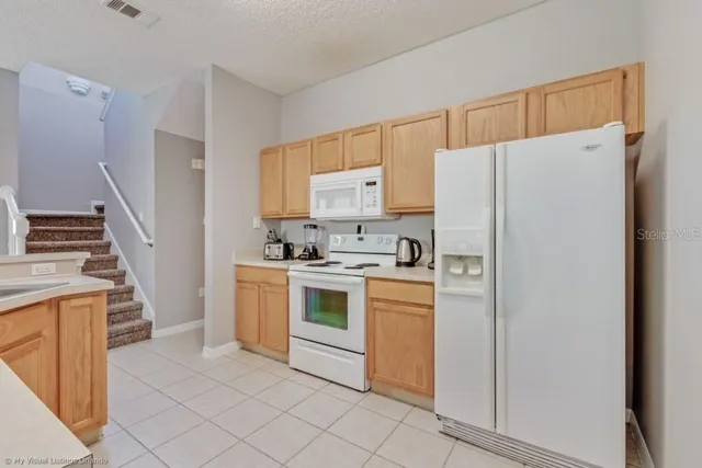 a kitchen with white cabinets and white appliances