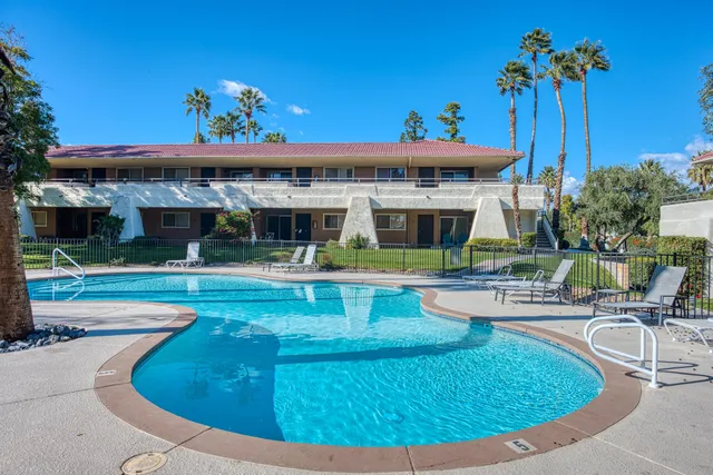 a view of a tennis ground with large trees