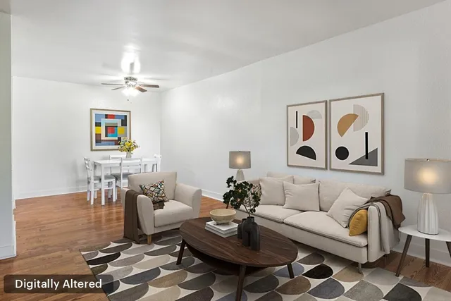 a view of a room with wooden floor and a chandelier fan