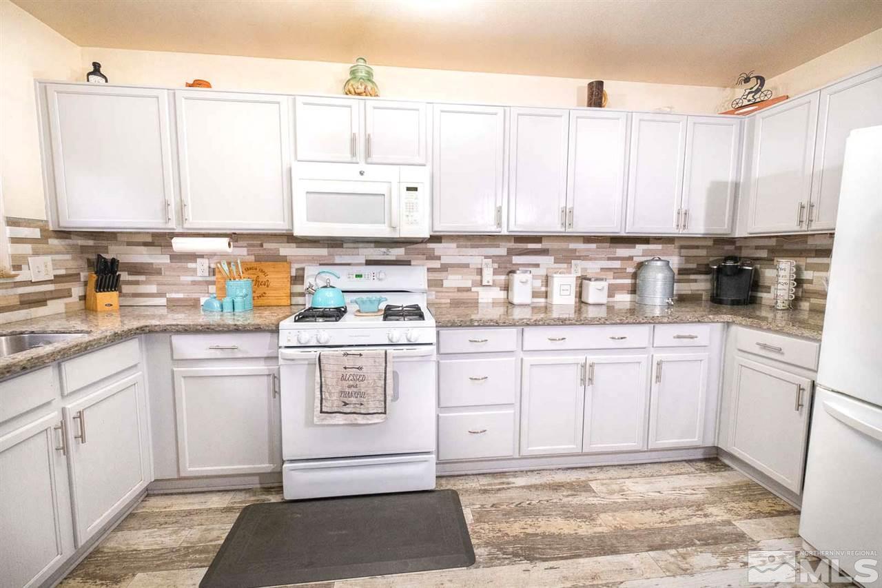 7720 Tulear Street Reno, NV 89506 - Photo 9 of 36 a kitchen with a white cabinets and white appliances