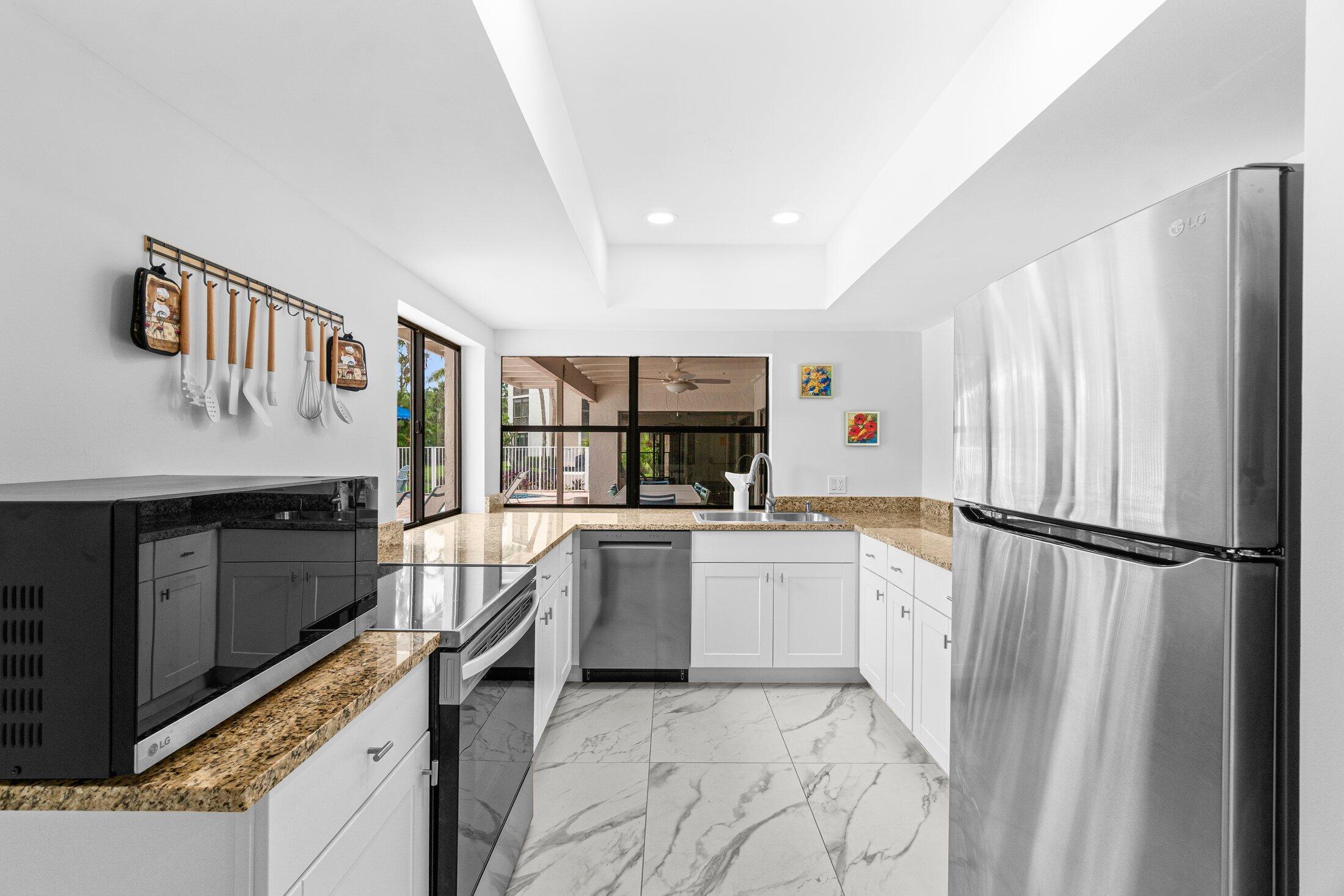 6562 Boca Del Mar Drive, Unit 527 Boca Raton, FL 33433 - Photo 35 of 38 a kitchen with a refrigerator and white cabinets