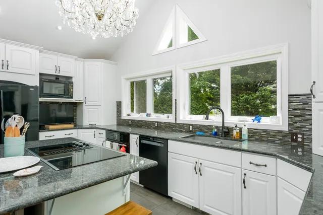 a kitchen with stainless steel appliances granite countertop a sink and a stove