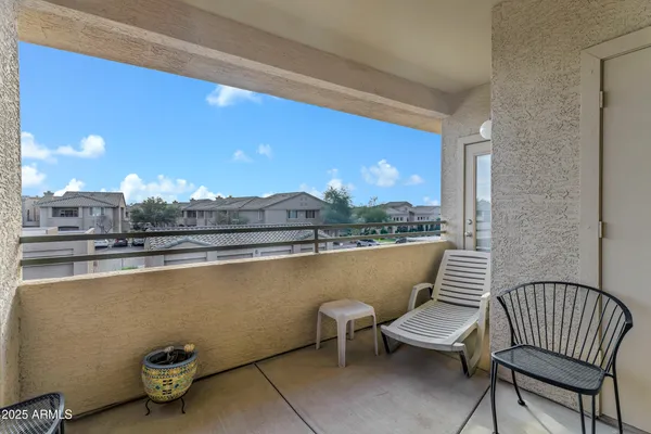 a view of a white house with large windows next to a road