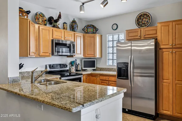 a kitchen with granite countertop a sink a stove and cabinets