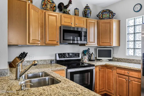 a kitchen with stainless steel appliances granite countertop a stove a sink and a microwave