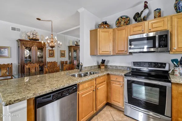 a kitchen with granite countertop a center island and some chairs