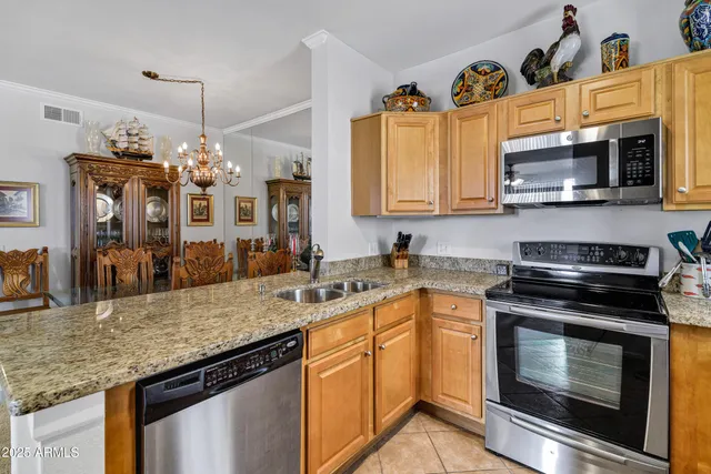 a kitchen with granite countertop a center island and some chairs