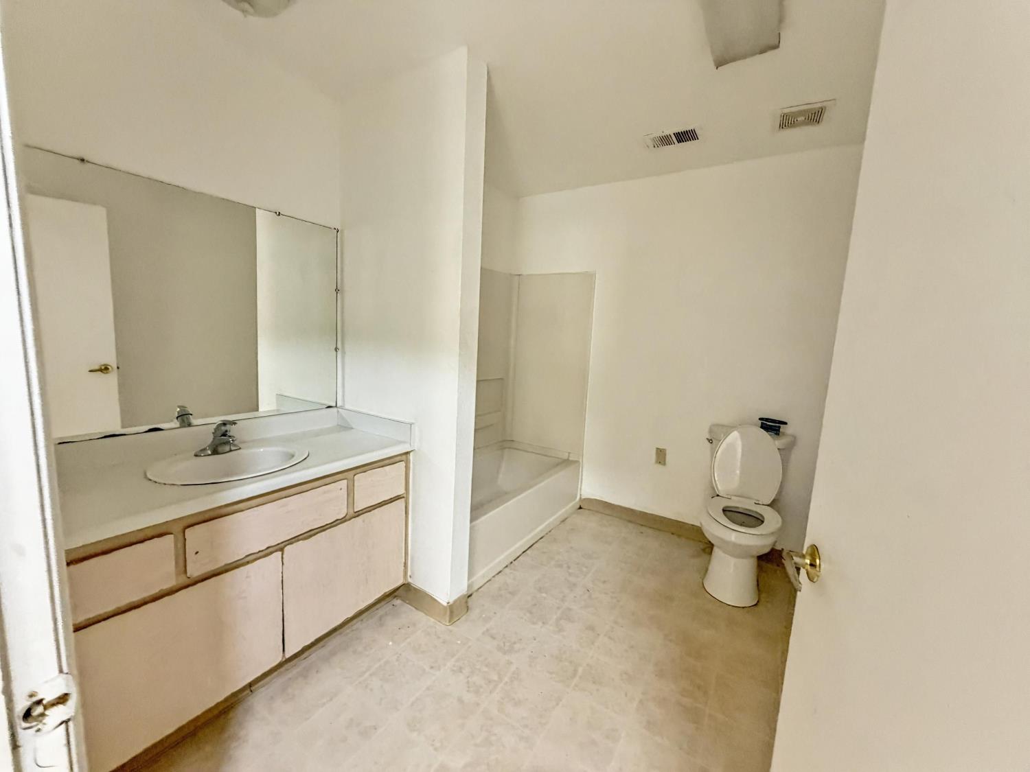 1405 East Cypress Avenue, Unit 137 Reedley, CA 93654 - Photo 11 of 15 a bathroom with a granite countertop sink mirror and toilet