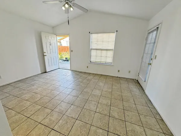 an empty room with windows and fan