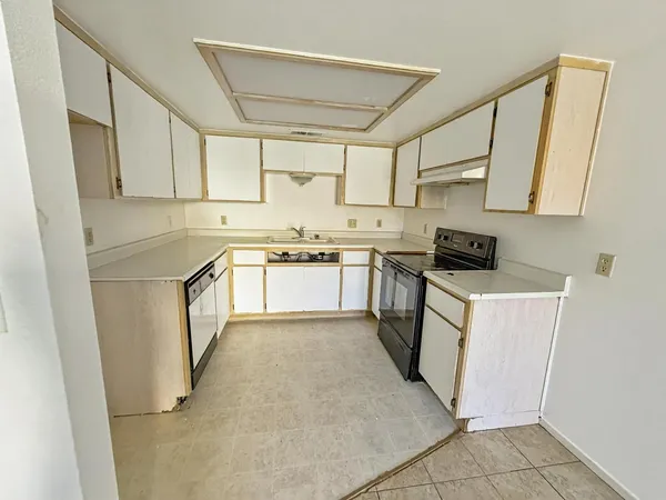 a kitchen with white cabinets stainless steel appliances