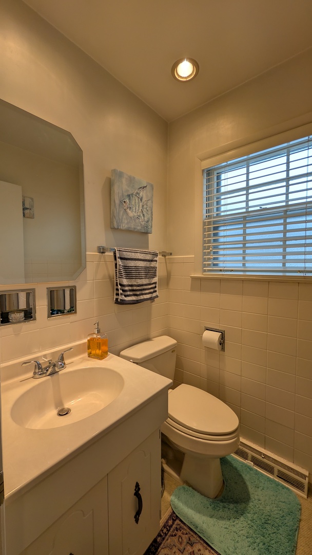 232 Kilpatrick Avenue Wilmette, IL 60091 - Photo 11 of 41 a bathroom with a sink a toilet and mirror