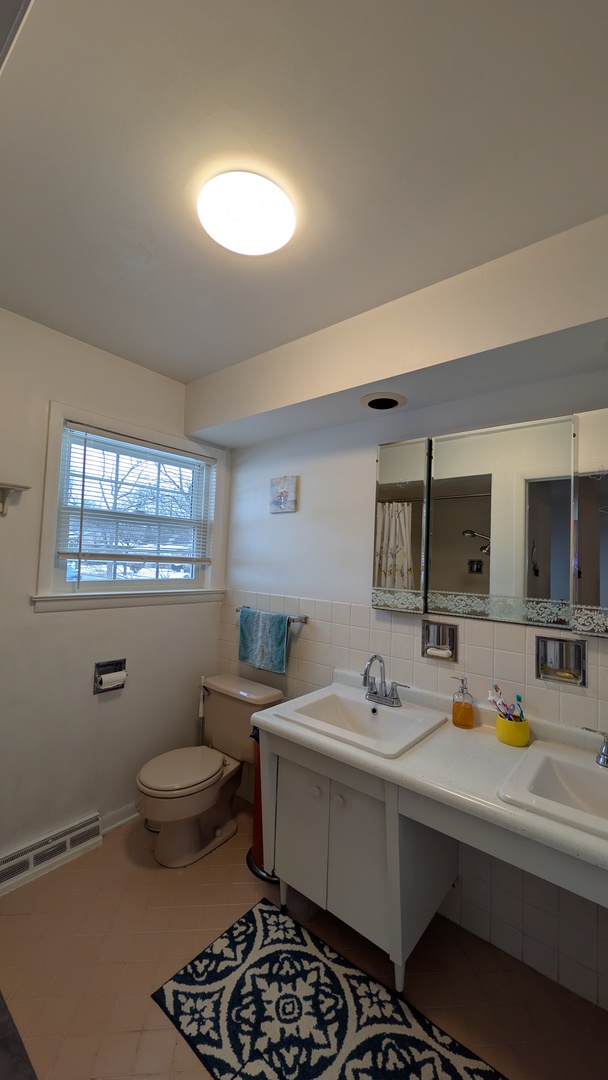 232 Kilpatrick Avenue Wilmette, IL 60091 - Photo 31 of 41 a bathroom with a sink mirror and toilet