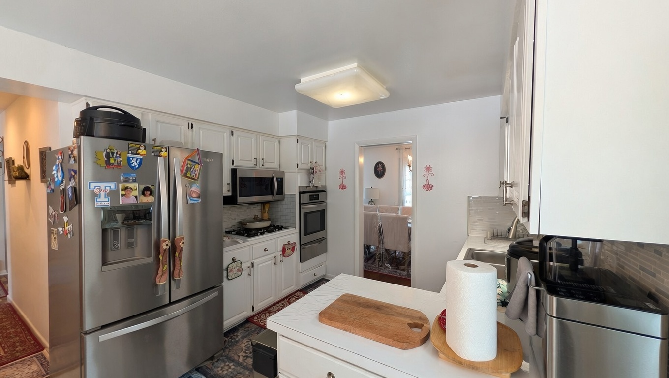 232 Kilpatrick Avenue Wilmette, IL 60091 - Photo 6 of 41 a kitchen with stainless steel appliances kitchen island granite countertop a refrigerator and a sink